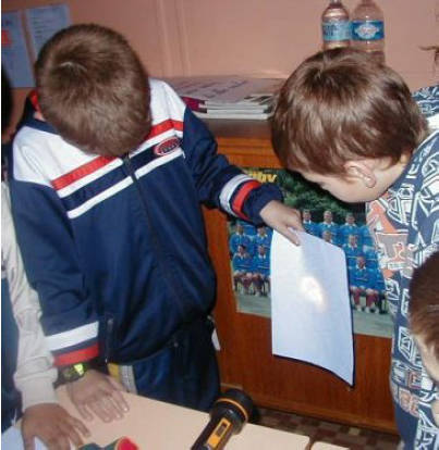 Foto zweier Kinder beim Experimentieren mi einer Taschenlampe