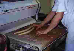 Foto eines Bäckers an einer Maschine