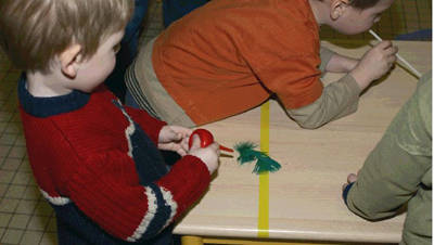 Foto: Kinder pusten Gegenstände über den Tisch