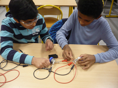 Foto: Zwei Jungs bauen einen geschlossenen Stromkreis zusammen
