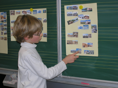 Foto: Ein Kind erklärt die
Zuordnungen Behausung/Landschaft an der Tafel