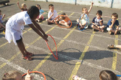 Foto: Kinder beobachten ein Mädchen mit Hula-Hoop-Reifen
	  und ihren Schatten